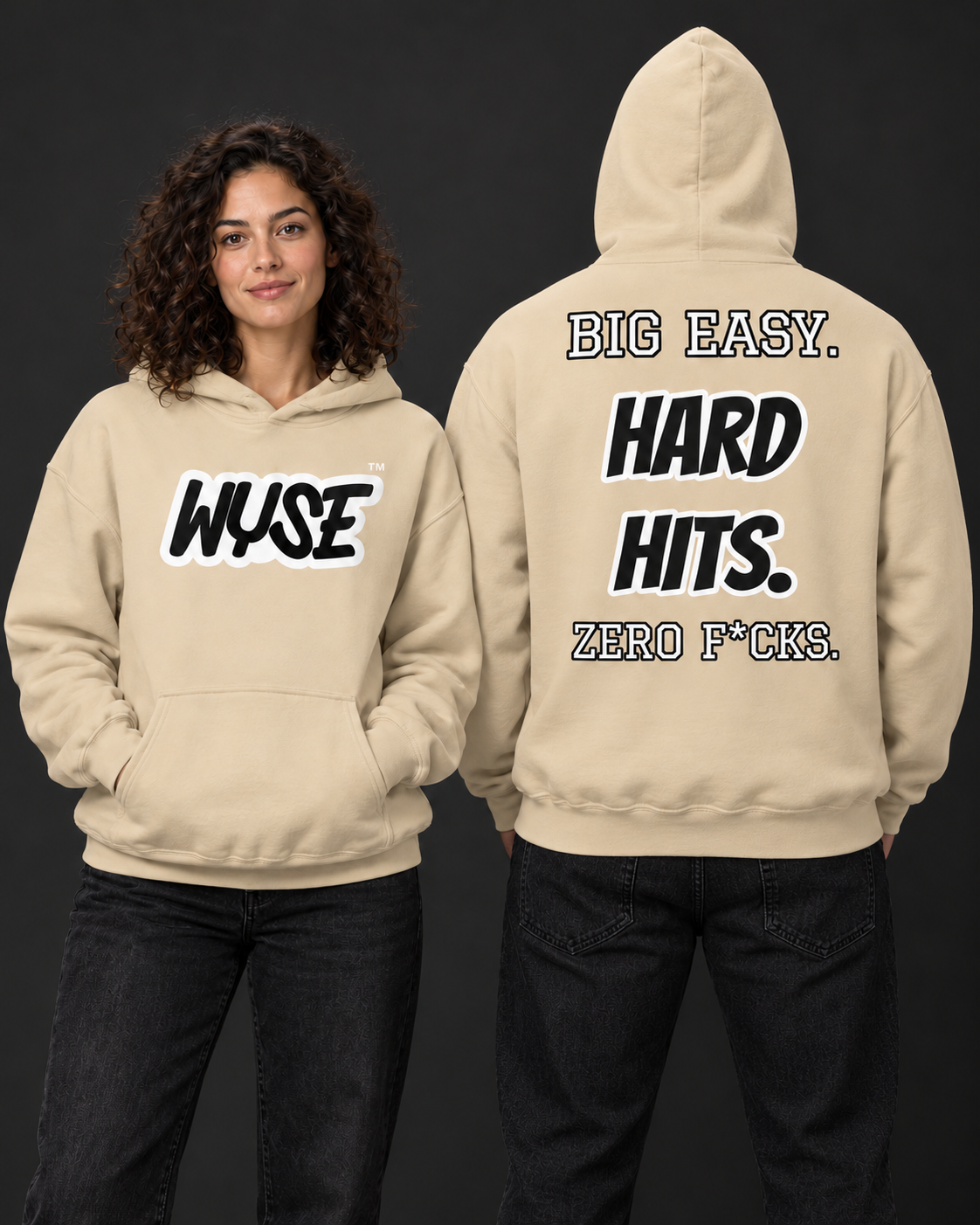 WYSE New Orleans Saints fan hoodie in sand, woman showing black WYSE front logo and athletic man facing fully away with Big Easy Hard Hits back print.